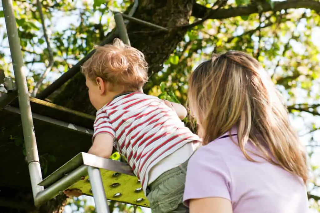 mom helping child climb stairs outside thanks to knowing authoritarian vs authoritative parenting