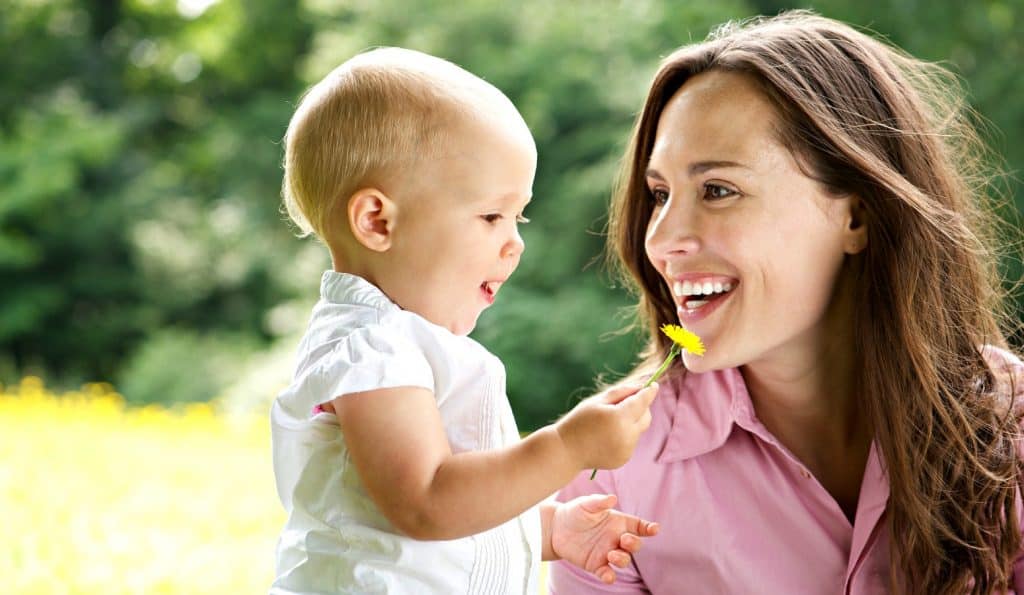 mom looking at baby daughter's flower while connecting with kids