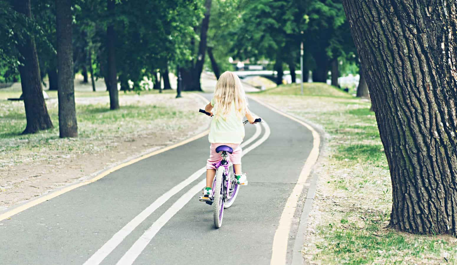 little girl riding bike by herself on the road free range parenting safely