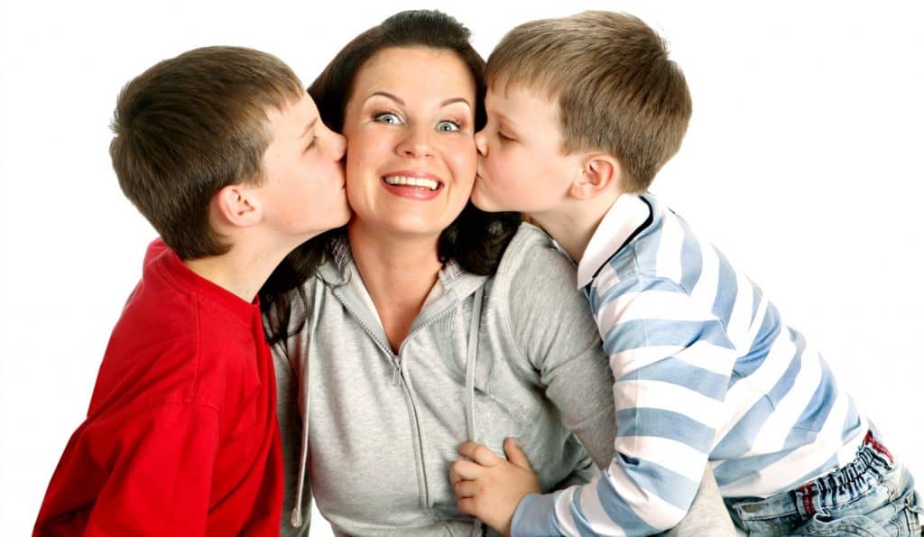 mom and boys giving her a kiss on the cheek