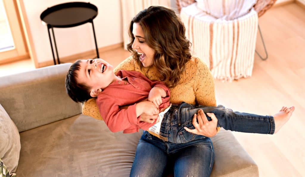 beautiful woman playing with her son on the floor when mom and boys have fun