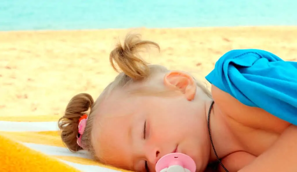 baby sleeping on the beach sunlight and melatonin for kids sleep